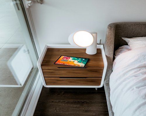 A calming cup of tea and a glass of water on a modern bedside table